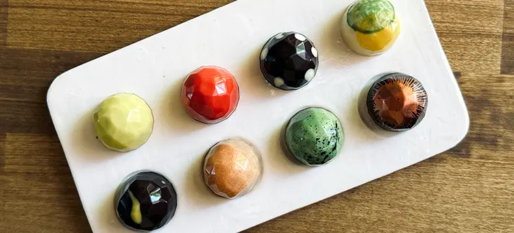 Catálogo bombones ¡Sumérgete en un mundo de sabores puros y colores vibrantes con nuestros bombones artesanales! Cada pieza, pintada a mano y elaborada con ingredientes orgánicos y de comercio justo, es una expresión de nuestro compromiso con la calidad y la sostenibilidad.