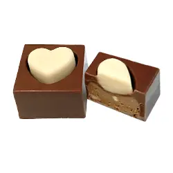 Bombón CORAZÓN AVELLANA. Bombón corazón de chocolate con leche de almendra 46% relleno de praliné rústico de avellana, suave y naturalmente tostado.