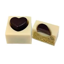 Bombón CORAZÓN PISTACHO. Bombón corazón de chocolate blanco vegano 35% relleno de praliné rústico de pistacho, cremoso y con el sabor auténtico del fruto seco.